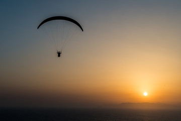 silhouette of paraglider at sunset