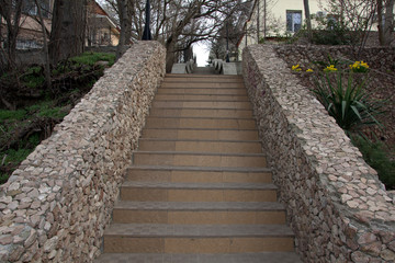 concrete staircase with fences made of small wild stone