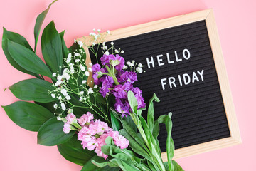 Hello Friday text on black letter board and bouquet colorful flowers on pink background. Concept Happy Friday. Template for postcard, greeting card Flat lay Top view