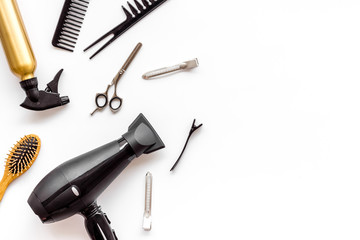 Professional hairdressing set with combs and hairdryer on white background top-down frame copy space