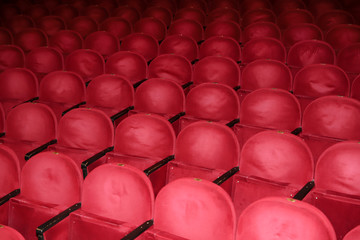 Classic rows of empty reddish seats in theatre