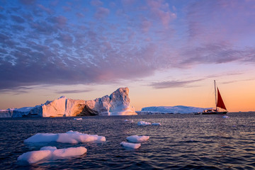 Obraz premium Greenland Ilulissat glaciers at ocean with red sailing boat