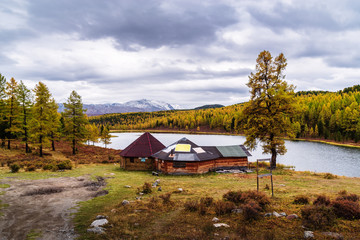 Roadside cafe for tourists on the shore of Lake Kidelu. Autumn taiga landscape. Ulagansky District, Altai Republic, Russia