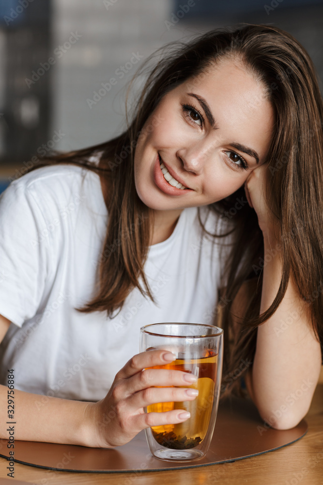 Poster Image of cheerful beautiful woman smiling and drinking tea