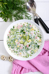 Cold summer soup okroshka. Light soup in a white bowl. Top view.