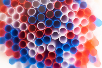 Colored cocktail plastic drinking straws rotates on white color background.