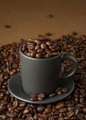 Fototapeta premium Cup and saucer with coffee beans on coffee surface