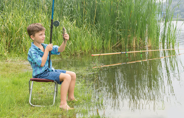 Little boy is fishing on the river