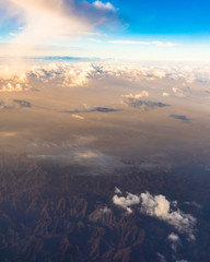 Aerial view of clouds and mountains landscape from airplane window seat © Captured Blinks