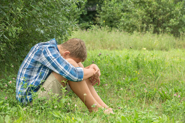 Fototapeta premium Sad thoughtful teenager sits alone