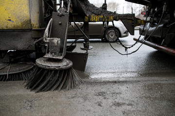 Brushes for cleaning the streets are fixed on the car. Special machinery. Machine with tassels. Car for cleaning in the city. Automatic road cleaning brushes. Washing sidewalks.