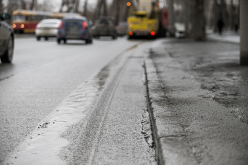 Road pits in the city in the spring after the snow melts. Problem of roads and asphalt in the city.