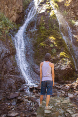 Naklejka premium hiker views the wild terrain at Rainbow Falls