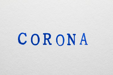 Fototapeta na wymiar a corona word stamped on a piece of paper.