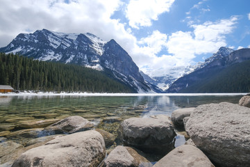 Mount fairview, partly frozen lake, rocks in foreground. Lake Louise Banff National Park, Alberta Canada