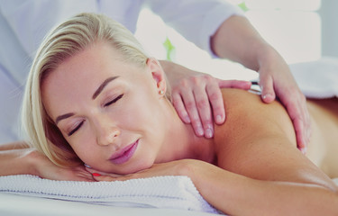 Beautiful spa woman lying on towel in spa salon