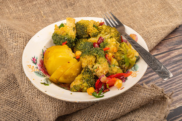 Vegetable salad in a white ceramic bowl and fork on a rough cloth background. Close up.