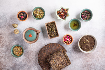 Assortment of dried tea in ceramic bowls. Black, green and herbal tea collections. Top view. Food background.