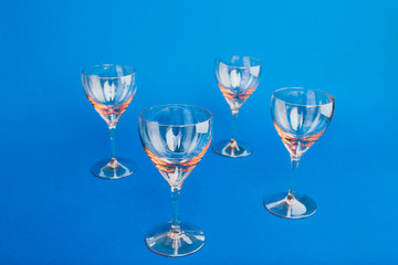 Empty glasses on blue background. Flat lay, copy space, top view.