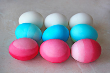 White, blue and pink Easter eggs on the table. Season's greetings card. Modern easter flat lay.