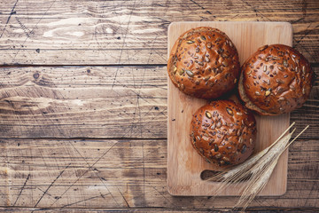 Bread products with cereals and seeds on a wooden background. Lean healthy buns, carbohydrate pastries. Copy space