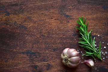 Sprig of rosemary with garlic and sea salt - traditional italian spices. Top view with copy space.