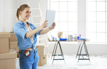 Woman taking selfie while smiling cheerfully, having moved into a new flat