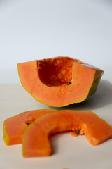 Sliced papaya on a white cutting board