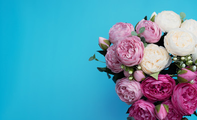 Pink and white flowers on blue background. Mother’s Day, Spring concept. Greeting, invitation card. Flat lay, top view style with copy space for your text.