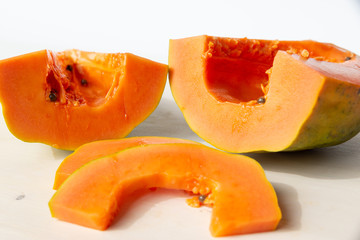 Sliced papaya on a white cutting board