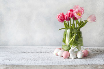 Spring Easter composition with pink tulips and eggs. Space for text. Close up.