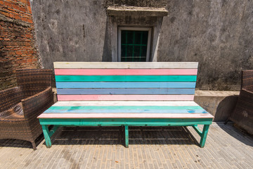striped colored wooden bench in front of house