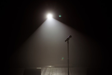 Fototapeta na wymiar microphone on the stage with black background