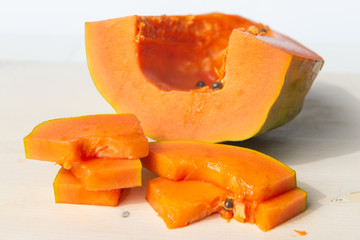 Sliced papaya on a white cutting board