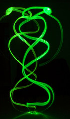 Vibrant neon waves with glow. Abstract bright neon loops with copy space. Colorful shine, flare. Illustration for advertising, banner, card. Green waves with light effect.
