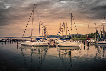 Sailingboats against sunset at Balaton, Hungary. Yachts in the port. Vintage toned.