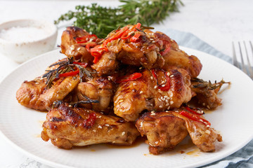Barbecue chicken wings. Oven baked chiken on plate. Hot korean food. Side view, close up