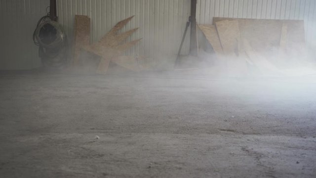 Dust flies over a dusty concrete floor