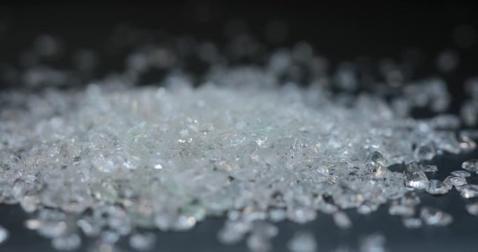 Sprinkle fraction of transparent glass material on black background