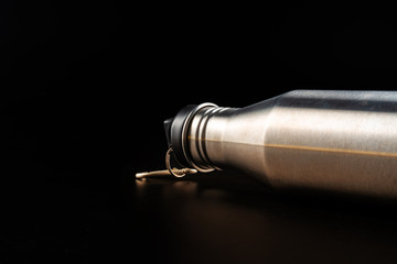 Sport bottle for drink on black background close up