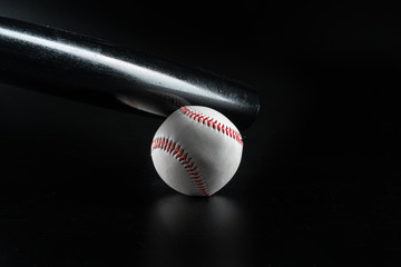 Baseball game equipment on dark black background close up
