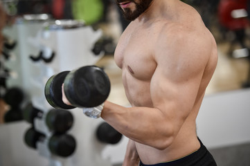 Man working out strength exercises in a fitness gym