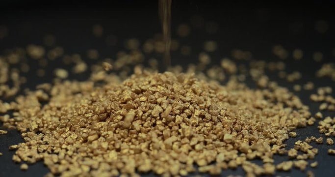 Gold mining, sprinkle fraction of rare metal on black background