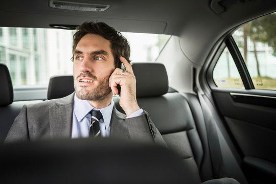 Businessmann im Auto am Handy