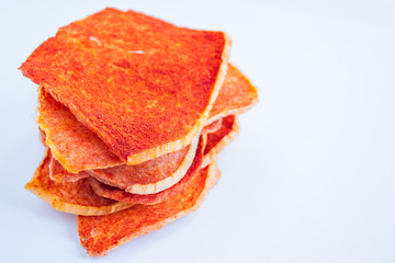 Dried slices of pork, beef of various shapes with spices on a white background. Crispy meat chips. Tasty appetizer. selective focus. Space for text. Bright light.