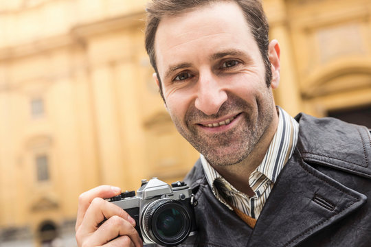 Portrait Mann mit Retro Kamera in st&auml;dtischen Umfeld