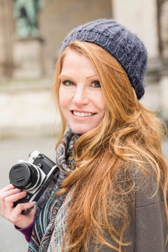 Frau mit Retro Kamera im staedtischen Umfeld