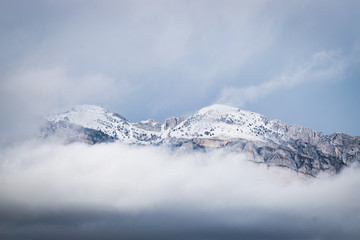 Snowy mountain peaks seen between the clouds.