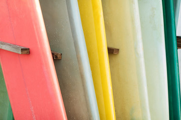 Set of colorful surfboard for rent on the beach. Multicolored surf boards different sizes and colors surfing boards on stand, surfboards rental place