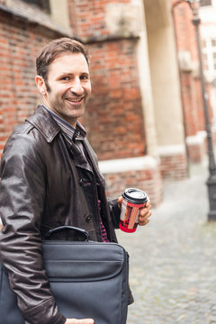 Businessmann mit Coffee to. go im st&auml;dtischen Umfeld